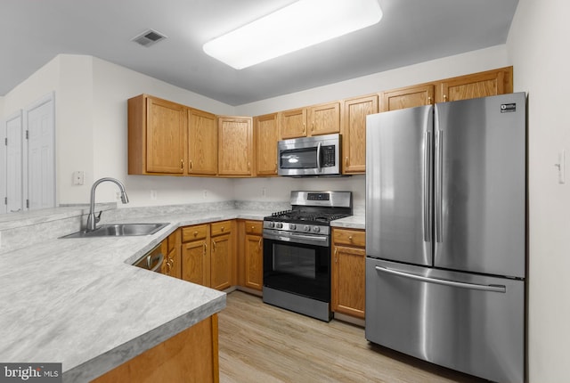 kitchen with light countertops, stainless steel appliances, visible vents, and a sink