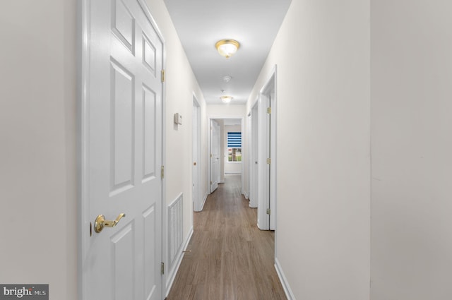 corridor with light wood-type flooring and visible vents