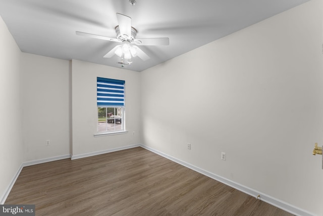 empty room with baseboards, ceiling fan, and wood finished floors