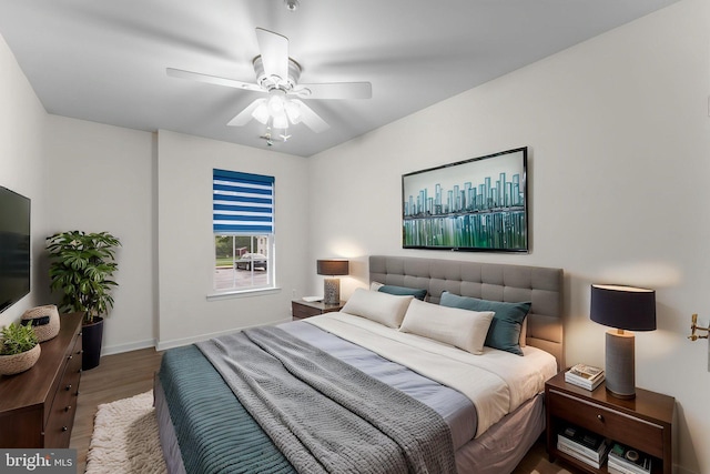 bedroom with baseboards, a ceiling fan, and wood finished floors