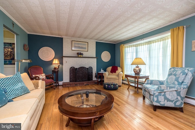 living area with crown molding, baseboard heating, a brick fireplace, and wood-type flooring