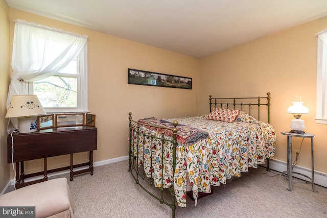 carpeted bedroom with baseboards and a baseboard heating unit