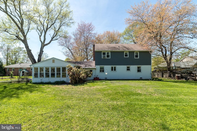 rear view of property with a lawn, fence, and a sunroom