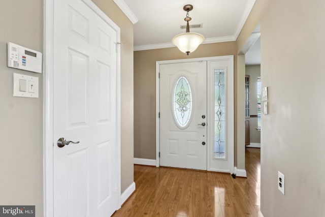 entrance foyer with visible vents, light wood-type flooring, crown molding, and baseboards