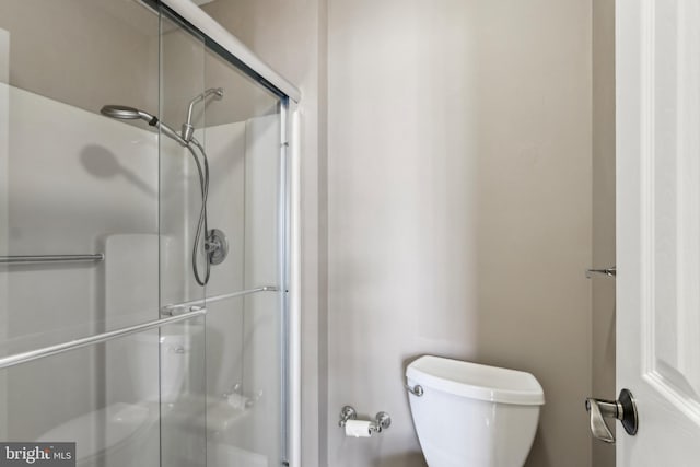 bathroom with toilet and a shower stall