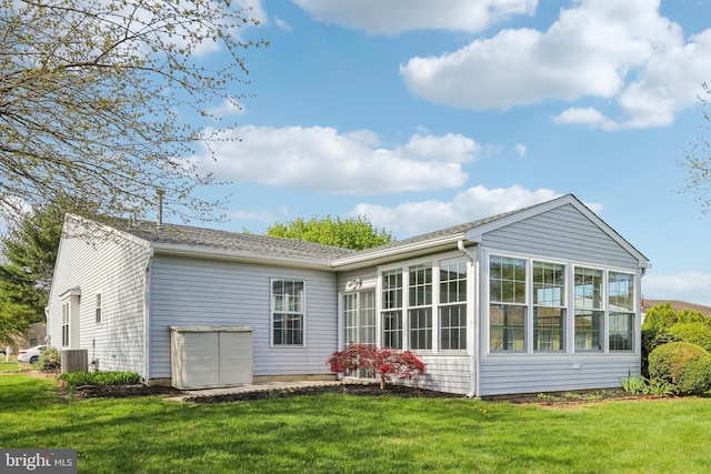 back of house featuring a yard, a sunroom, and central air condition unit