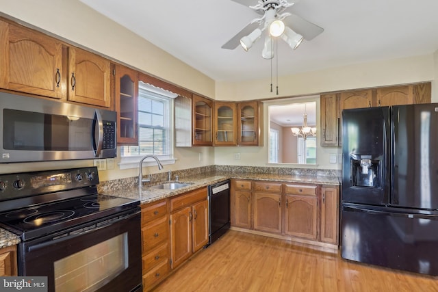 kitchen featuring black appliances, brown cabinets, and a sink