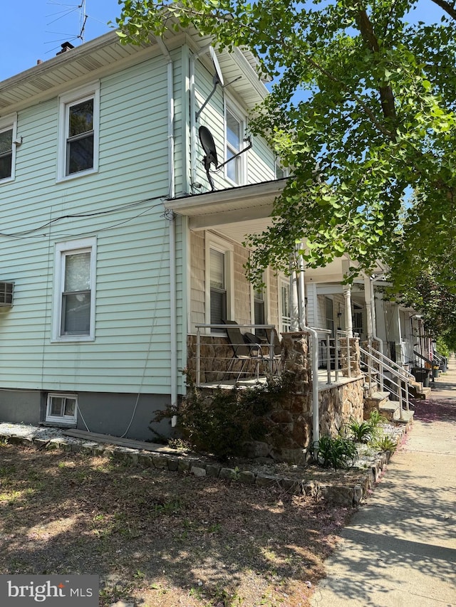 view of side of property featuring covered porch