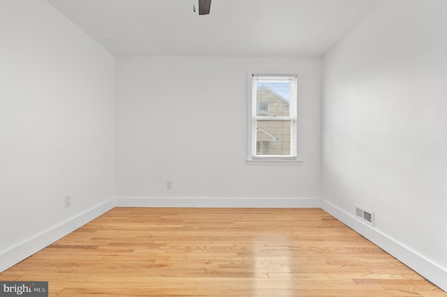 empty room featuring visible vents, ceiling fan, light wood-style floors, and baseboards
