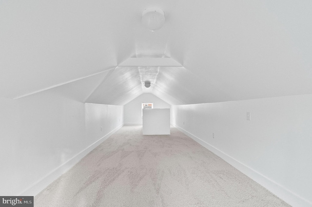 additional living space featuring baseboards, carpet floors, and vaulted ceiling