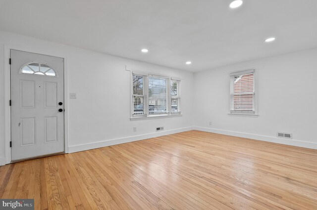 foyer entrance featuring visible vents, baseboards, light wood-style flooring, and plenty of natural light