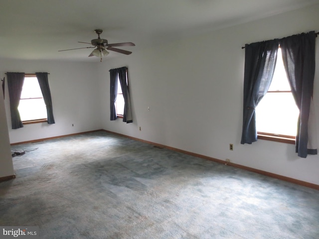 spare room with carpet floors, a wealth of natural light, and ceiling fan