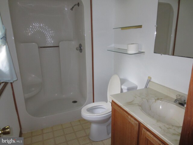 bathroom featuring a shower stall, tile patterned floors, vanity, and toilet