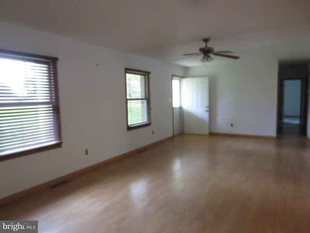 unfurnished room featuring a ceiling fan, baseboards, and light wood-style floors