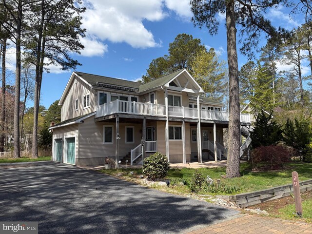 view of front of house with a garage, driveway, stairway, and a deck