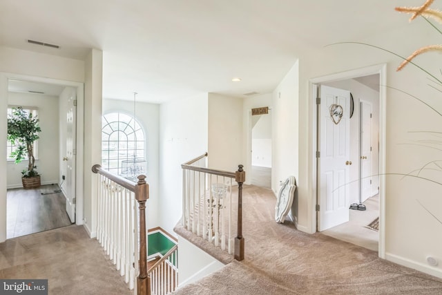 hall with baseboards, recessed lighting, visible vents, an upstairs landing, and carpet floors