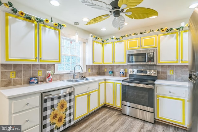 kitchen with appliances with stainless steel finishes, beverage cooler, a sink, and light countertops