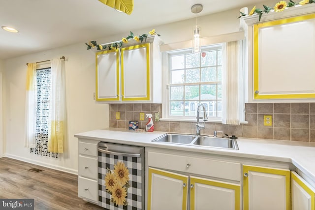 kitchen featuring wood finished floors, a sink, light countertops, backsplash, and wine cooler