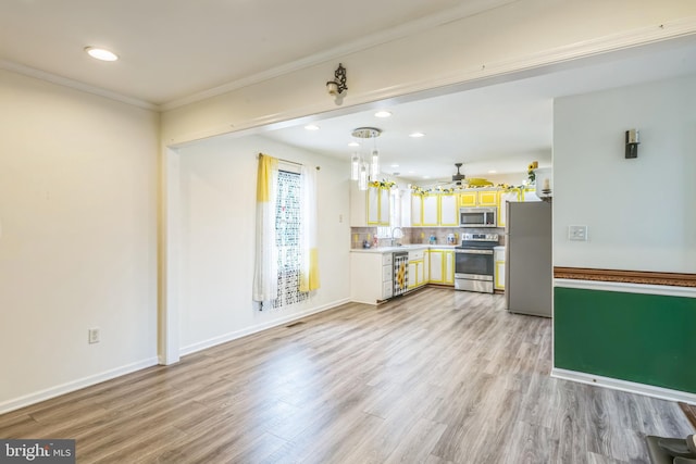 interior space with stainless steel appliances, light wood-style flooring, a sink, a ceiling fan, and light countertops