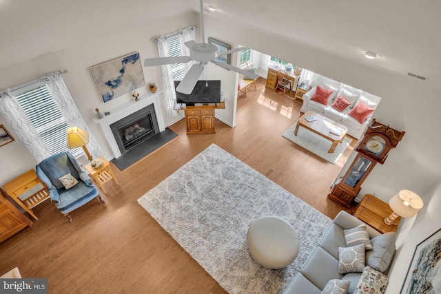 323 Valor Dr, Mechanicsburg, PA 17050 - living area featuring visible vents, a glass covered fireplace, wood finished floors, and a wealth of natural light