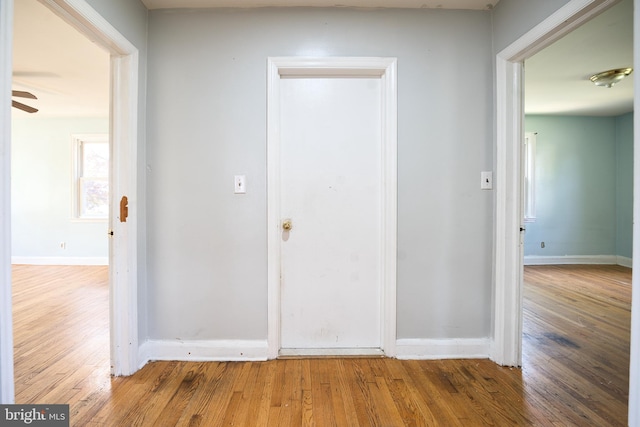 corridor featuring baseboards and wood finished floors
