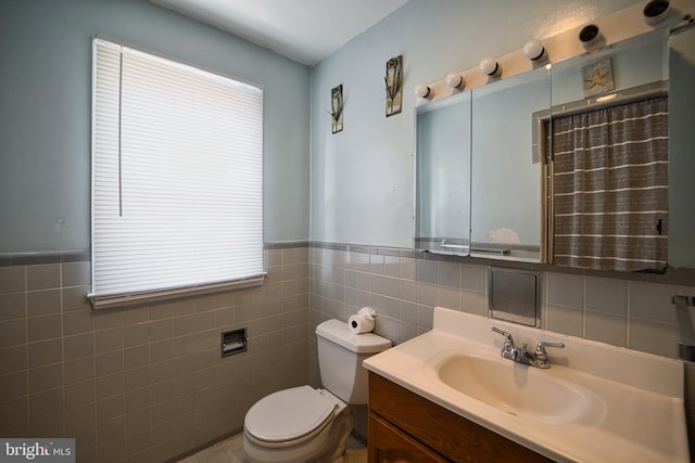 full bathroom featuring toilet, tile walls, plenty of natural light, and vanity