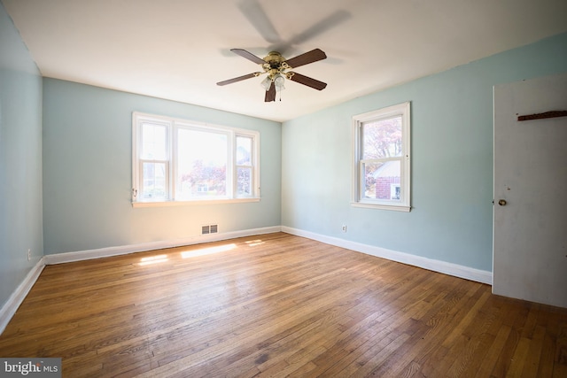 empty room with baseboards, ceiling fan, and wood-type flooring