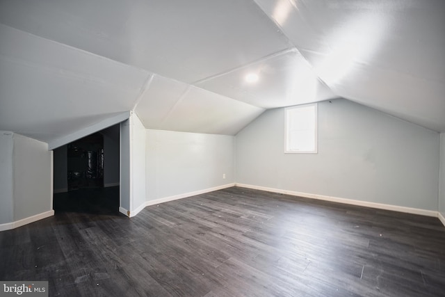 additional living space with baseboards, wood finished floors, and lofted ceiling