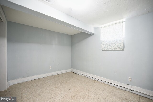 basement with tile patterned floors and baseboards