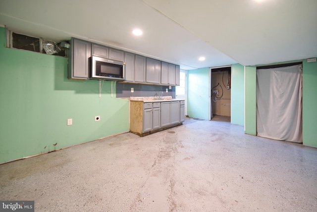 kitchen with recessed lighting, light countertops, stainless steel microwave, and gray cabinetry