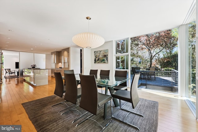 dining space featuring light wood-style floors and a wall of windows