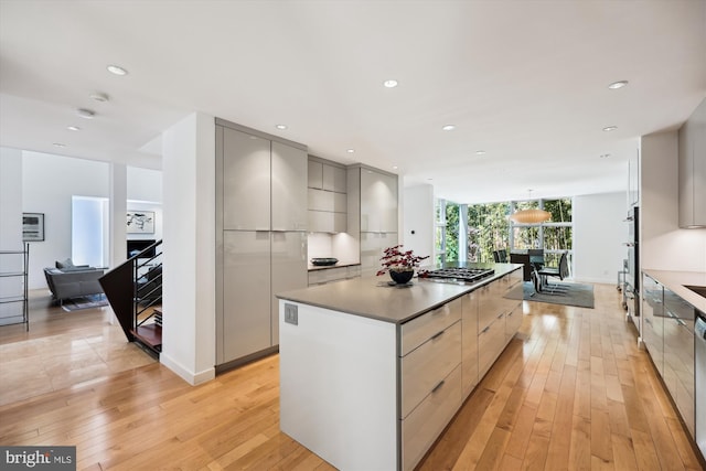 kitchen featuring modern cabinets, a kitchen island, gray cabinetry, and stainless steel gas stovetop