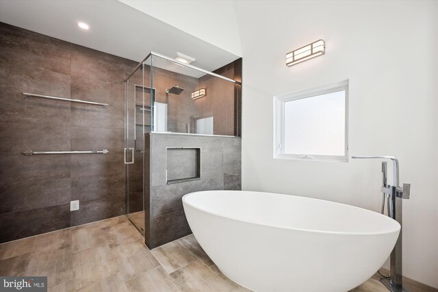 bathroom with a freestanding tub, a stall shower, and a fireplace