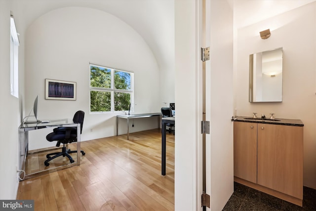 office with a sink, lofted ceiling, and wood finished floors