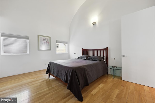 bedroom with a high ceiling and light wood finished floors