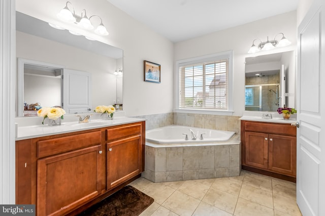 bathroom featuring a stall shower, a bath, tile patterned flooring, and two vanities