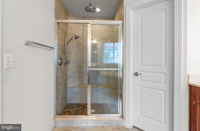 bathroom with a stall shower, vanity, and baseboards