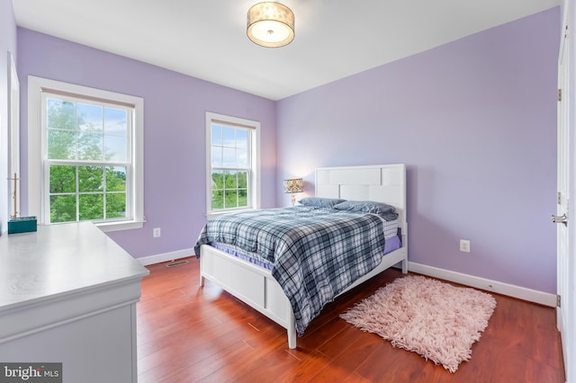 bedroom with baseboards and wood finished floors