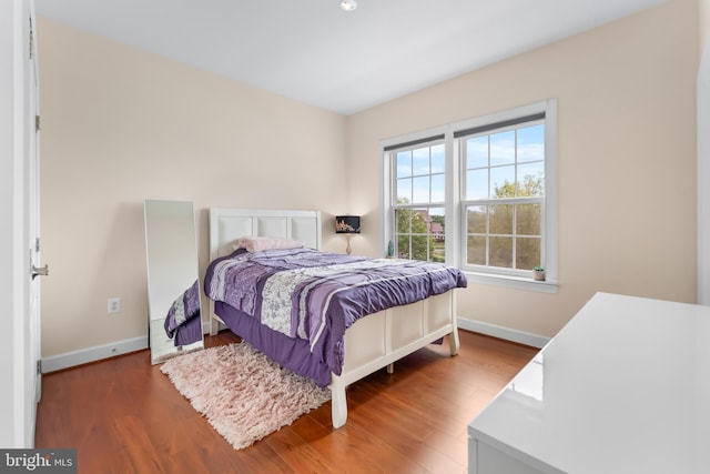 bedroom featuring baseboards and wood finished floors