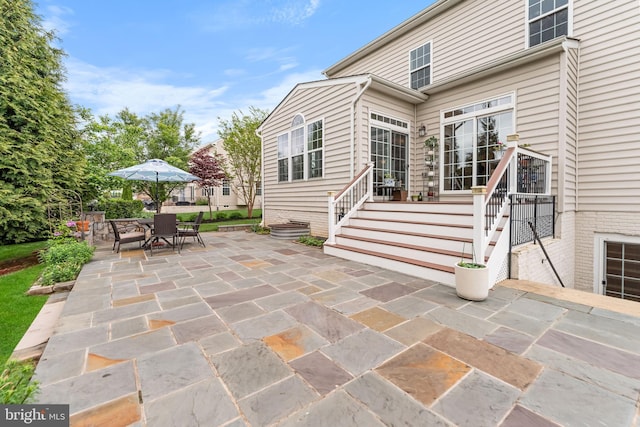 rear view of house featuring a patio and outdoor dining space