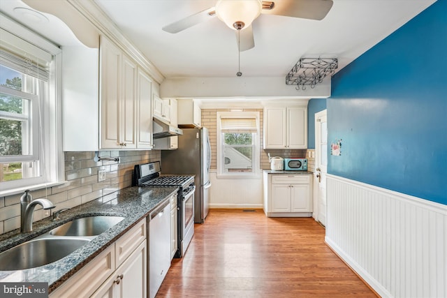 5218 Arbutus Ave, Baltimore, MD 21227 - kitchen with a sink, under cabinet range hood, stainless steel appliances, plenty of natural light, and wainscoting