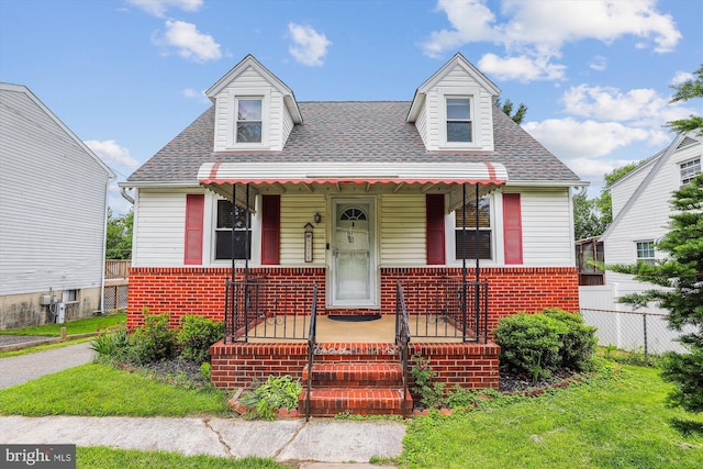 5218 Arbutus Ave, Baltimore, MD 21227 - view of front of house featuring a porch, brick siding, and roof with shingles