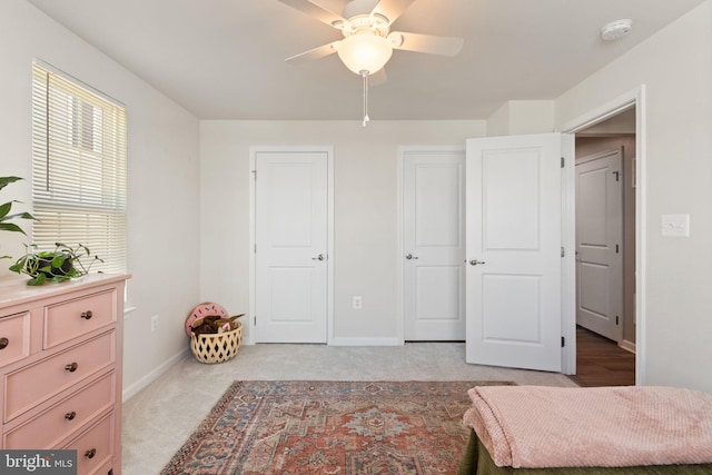 bedroom with baseboards, a ceiling fan, and light carpet