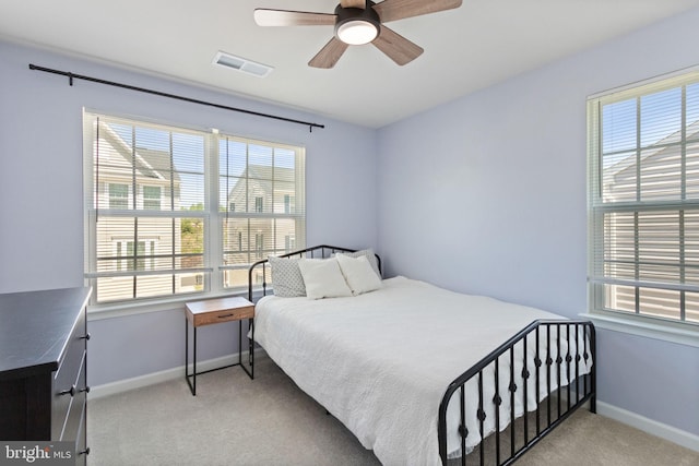 bedroom featuring baseboards, visible vents, light carpet, and ceiling fan