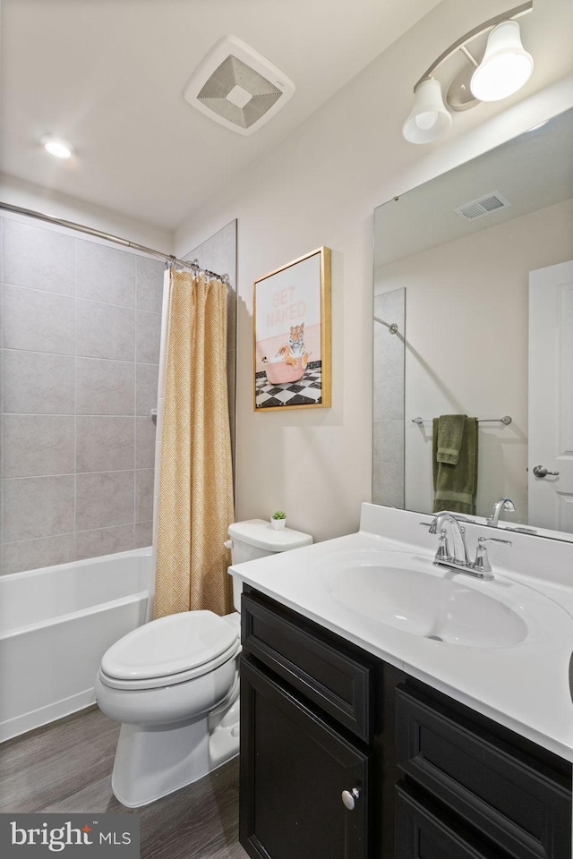 full bathroom with visible vents, wood finished floors, vanity, toilet, and shower / bath combo with shower curtain