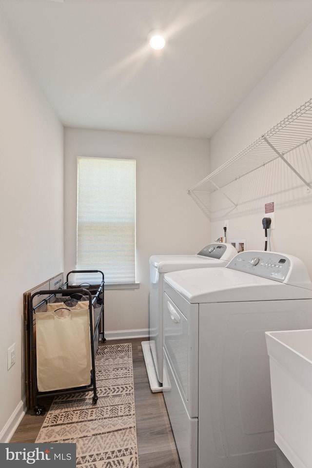 laundry area with laundry area, washer and clothes dryer, and dark wood-type flooring
