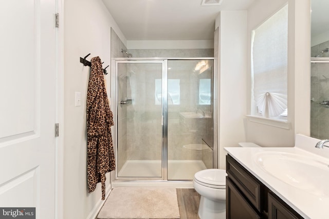 full bath featuring vanity, toilet, and a shower stall