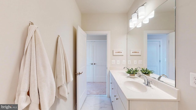 bathroom with double vanity, baseboards, a sink, and marble finish floor
