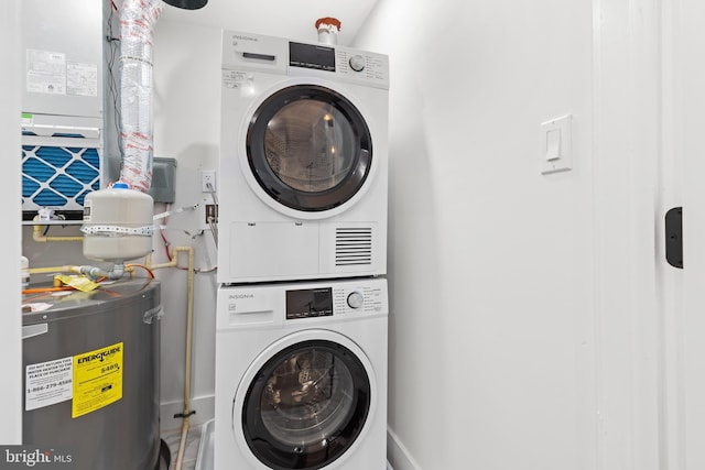 laundry room with stacked washing machine and dryer and electric water heater