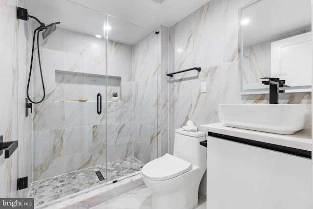 bathroom with tile walls, marble finish flooring, toilet, vanity, and a marble finish shower